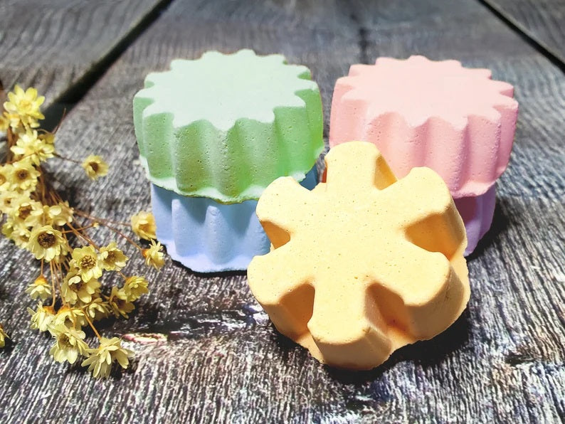 Colorful star-shaped bath bombs with dried flowers on a wooden surface