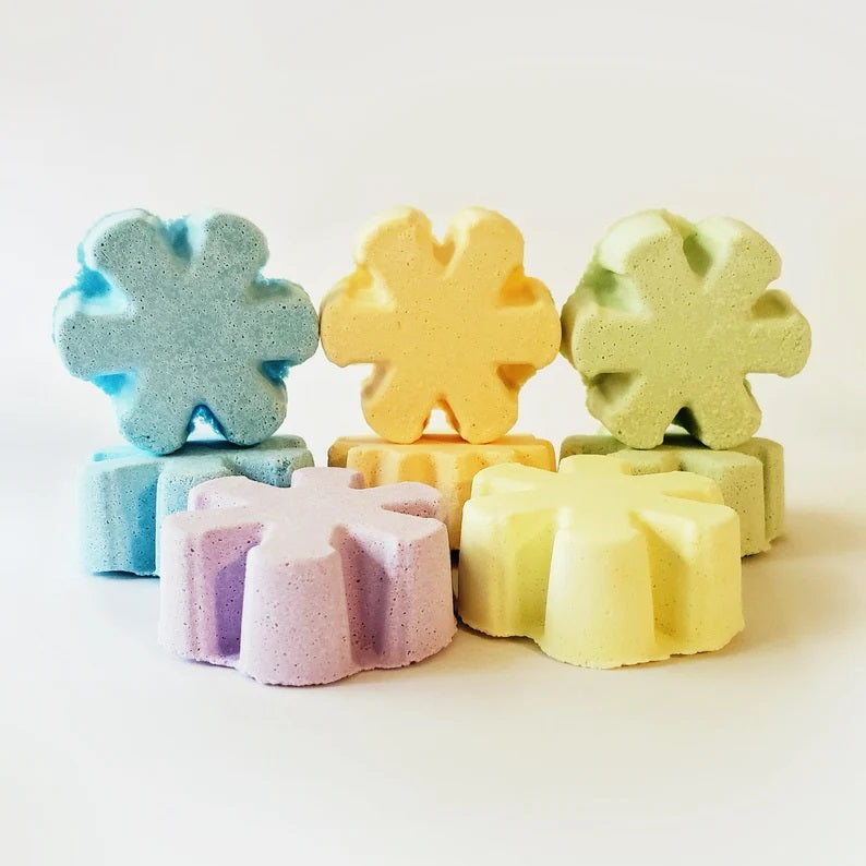 Six colorful flower-shaped bath bombs arranged in rows