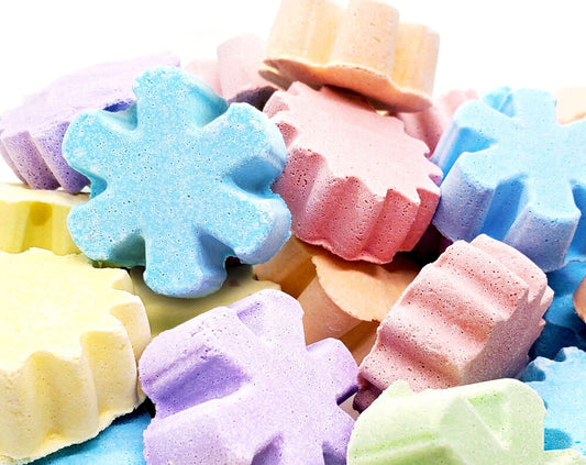 Pile of colorful bath bombs in various shapes and colors.