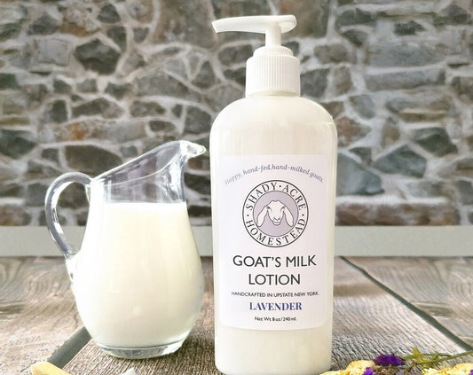 Bottle of Shady Acre Homestead goat's milk lotion next to a glass pitcher of milk.