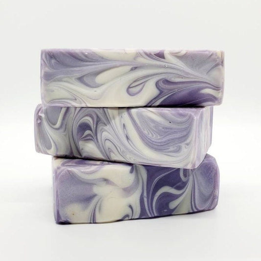 Stack of artisanal marbled soap bars in shades of purple and white